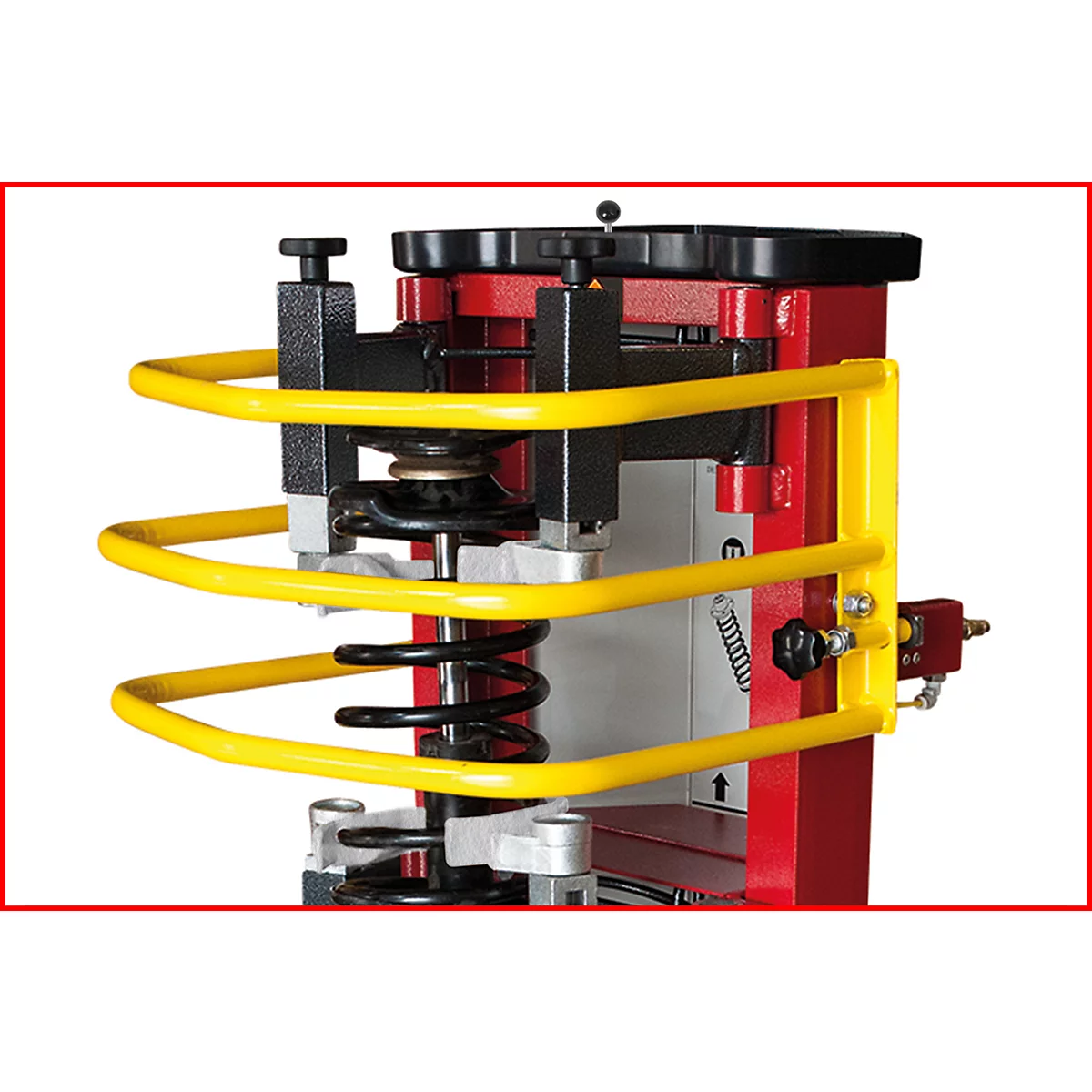 Maschinen-Detailaufnahme: Gelbes Schutzgeländer, rote Säule, schwarze Feder und Bedienelemente.